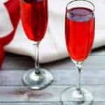 Champagne Grenadine Spritzer with a white napkin and red and white ribbons.