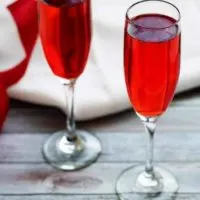 Champagne Grenadine Spritzer with a white napkin and red and white ribbons.
