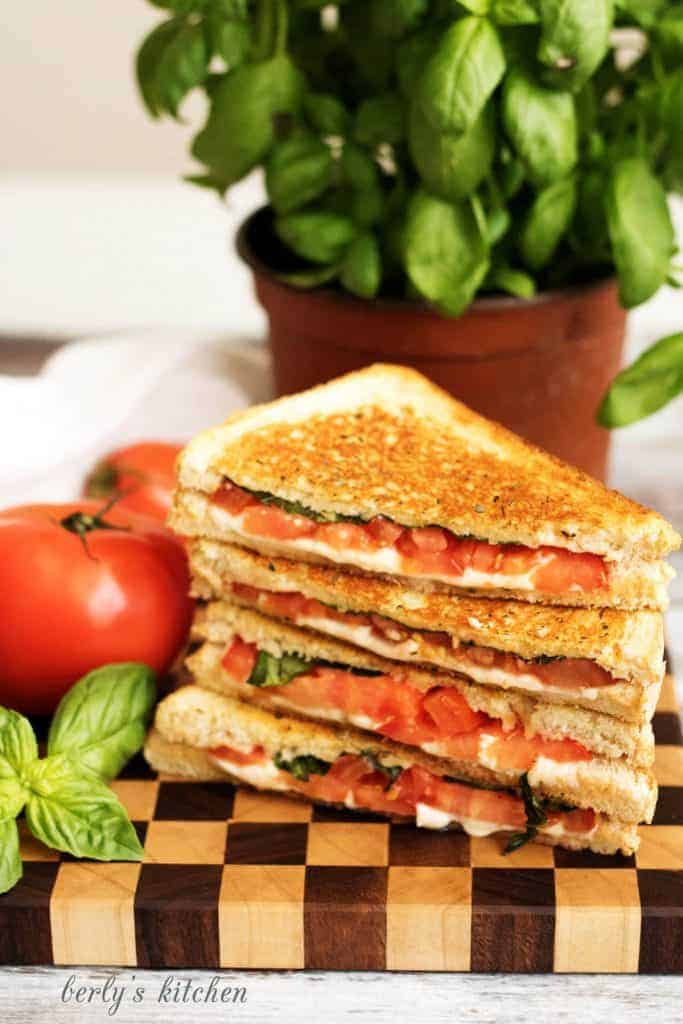 A grilled cheese margarita sandwich with perfectly toasted sourdough and all the flavors of the famous pizza including basil, mozzarella, and tomatoes.