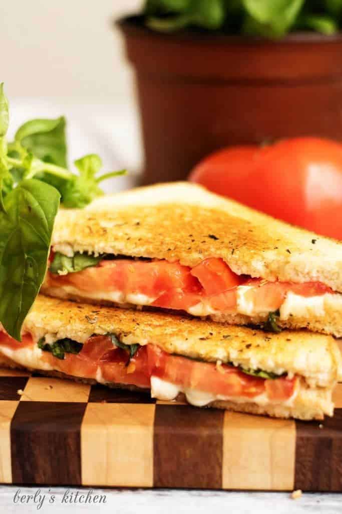 A grilled cheese margarita sandwich with perfectly toasted sourdough and all the flavors of the famous pizza including basil, mozzarella, and tomatoes.