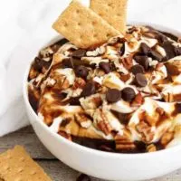 Turtle Cheesecake Dip with two graham crackers.