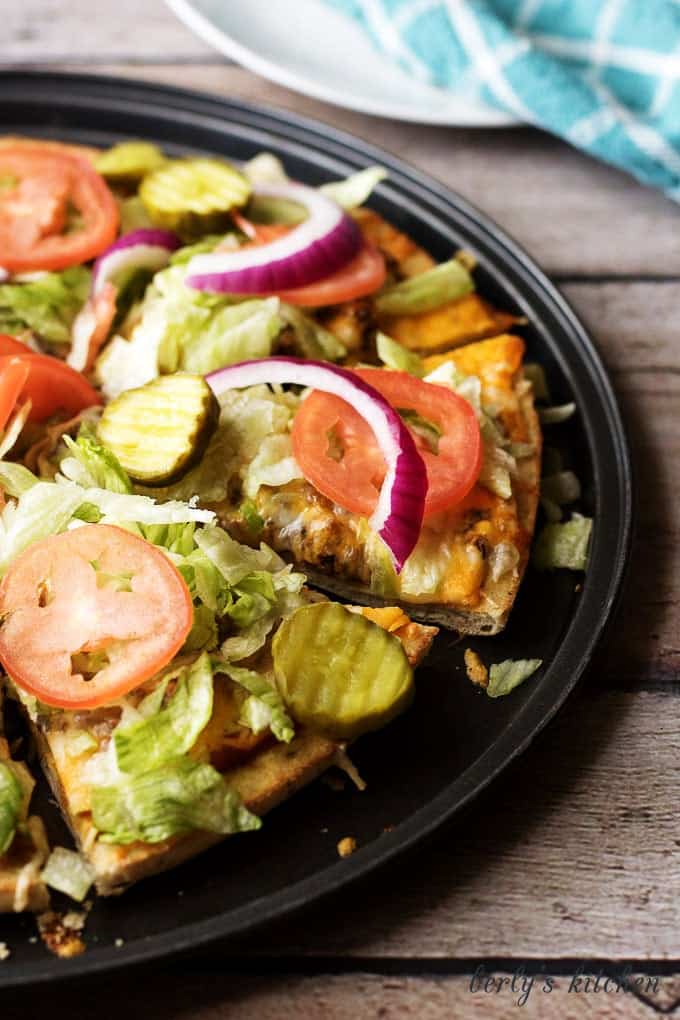 The works cheeseburger pizza is a simple to prepare recipe loaded with all the fixings, including lettuce, tomatoes, pickles, and onions.