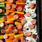 Spicy sausage and peppers in rows on a baking sheet.