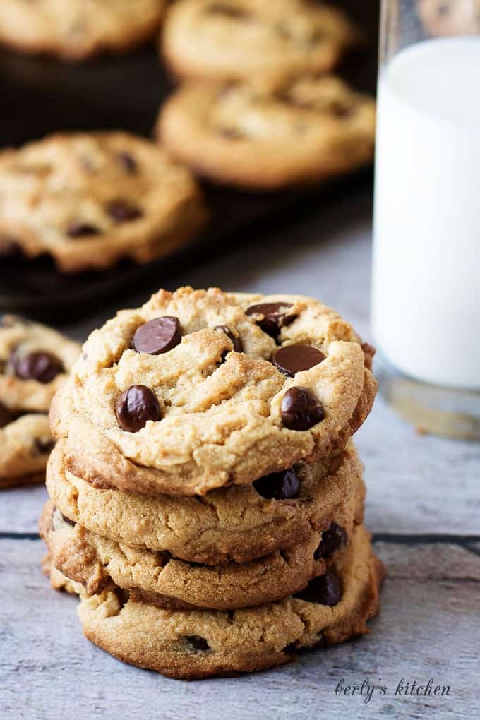 Stack of four chewy peanut butter cookies with chocolate chips.