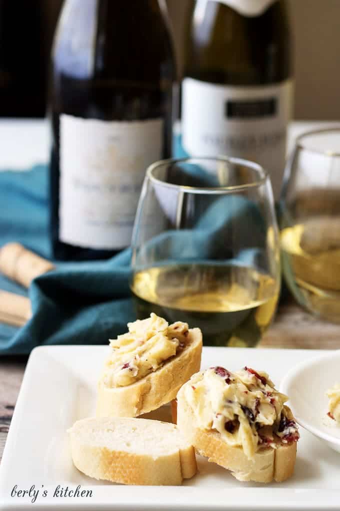 Cheese appetizers on a white plate with white wine.