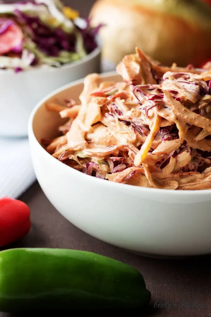 Spicy coleslaw recipe with white onion in the background.