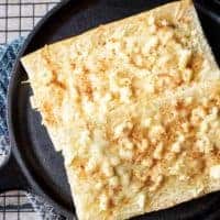 Feta mozzarella topped cheesy bread is the ultimate compliment or starter to any meal. We take Cuban bread, then top with feta, mozzarella, and garlic.