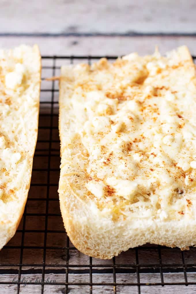 Close up of feta mozzarella topped cheesy bread on a cooling rack.