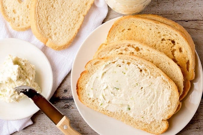 Sour cream and chives compound butter on sliced bread.
