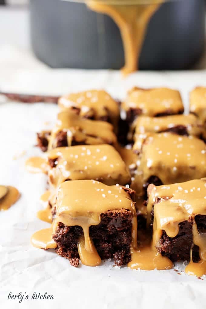 Close up of rows of brownies with sea salt and caramel sauce.