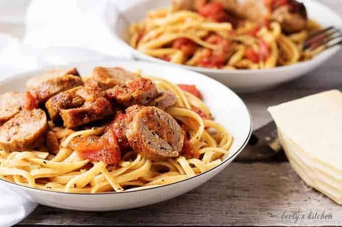 Spicy italian sausage and tomato linguine in a white pasta dish.