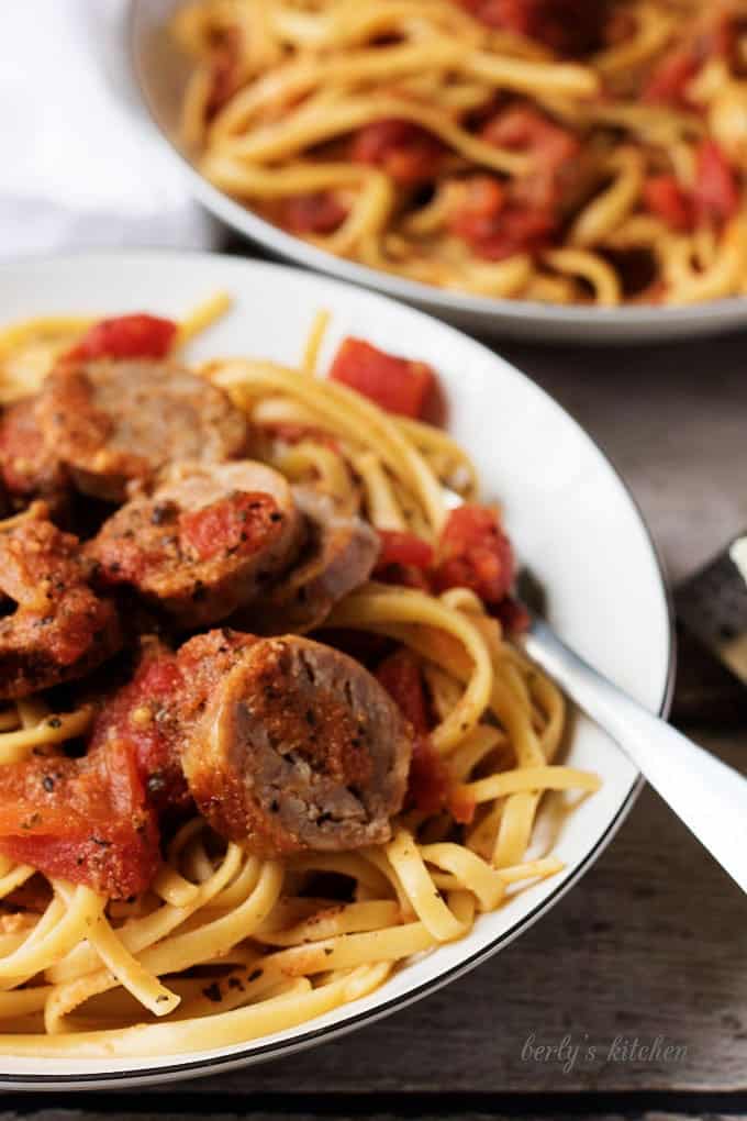 Close up of pasta, sausage, and tomato sauce with a fork.