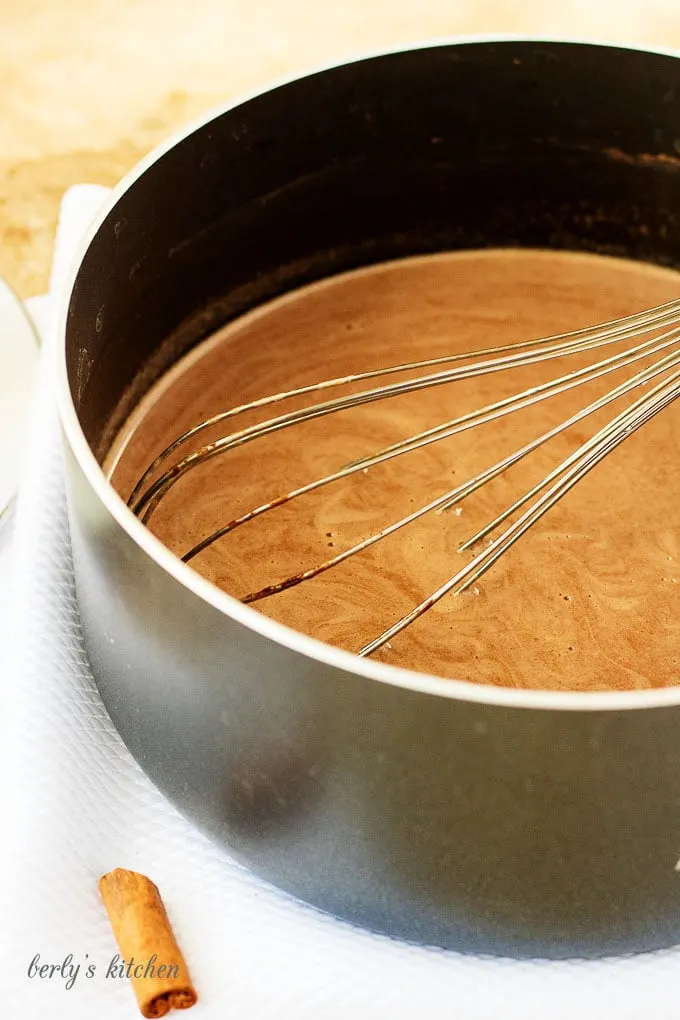 The hot cocoa being whisked in a saucepan.