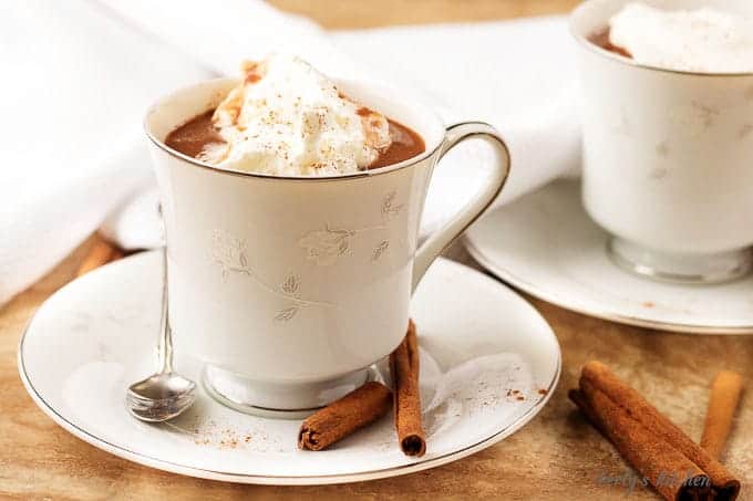 A cup of hot cocoa garnished with whipped cream.