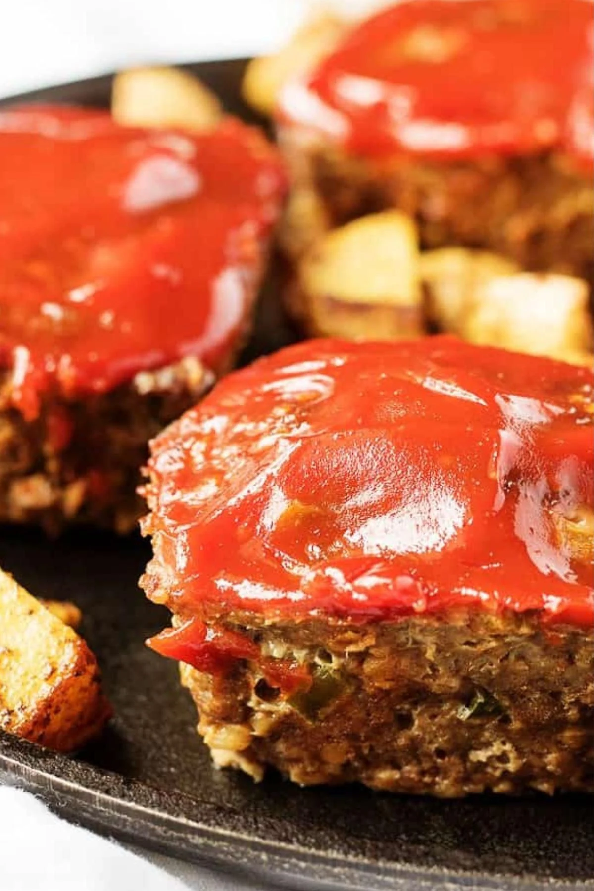 Close up view of a finished mini meatloaf recipe on skillet.