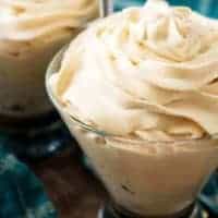 Irish cream flavored whipped cream in two cocktail glasses with blue towels.