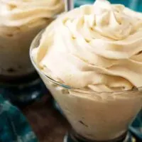 Irish cream flavored whipped cream in two cocktail glasses with blue towels.