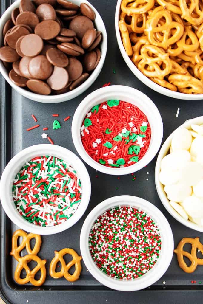 Top-down view of the ingredients, white and dark melting chocolate, mini-pretzels, and colorful sprinkles.