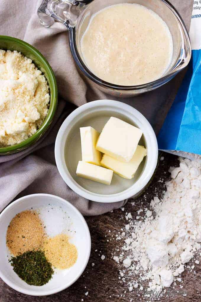 All of the ingredients like yeast, salt flour, butter and the spices in bowls.