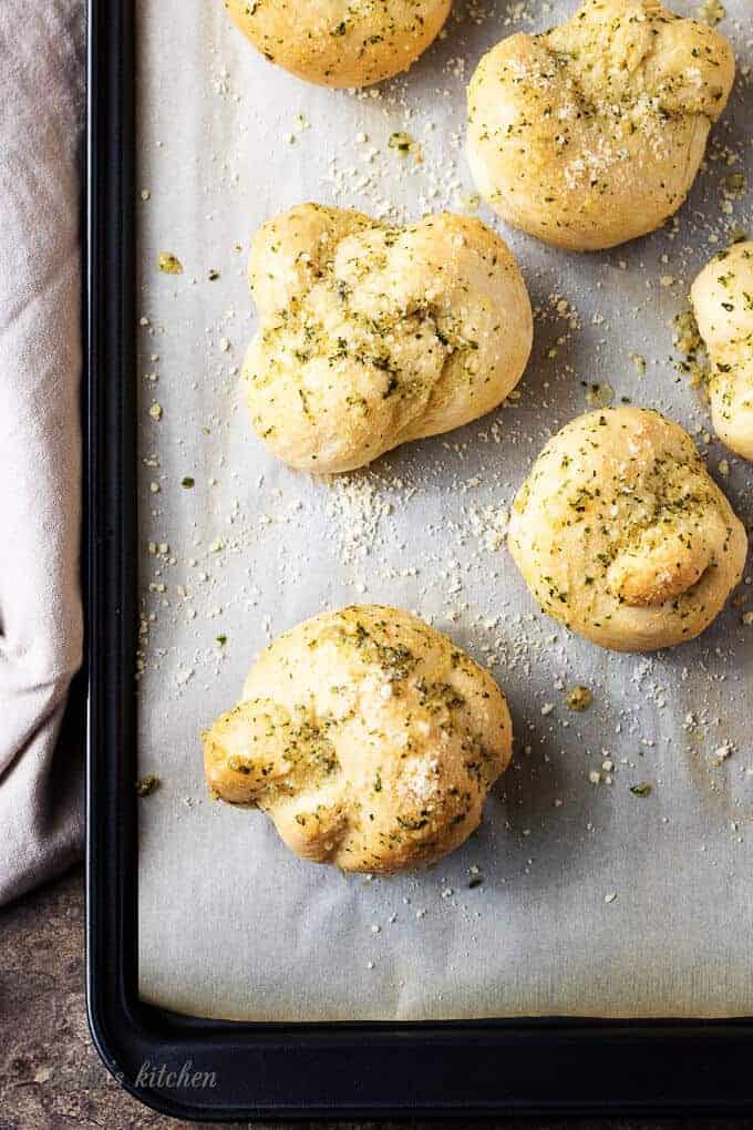 The finished garlic knots, baked, on a sheet pan ready to be buttered.
