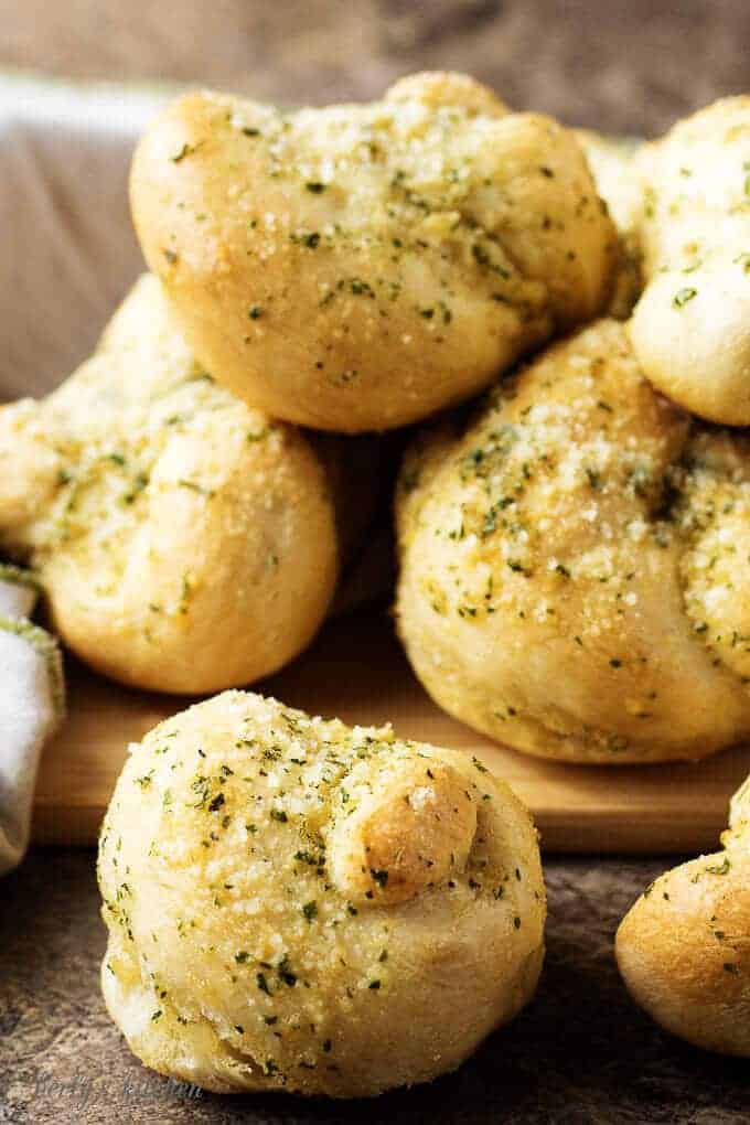 A close view of the finished Parmesan-butter topped garlic knots stacked up for serving.