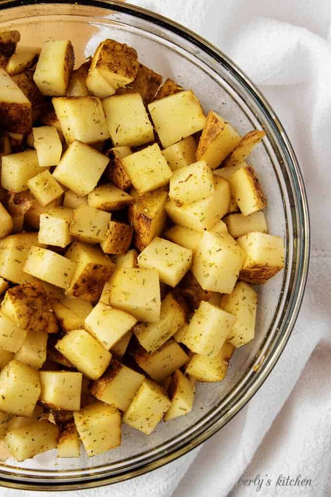 Top-down view of the potatoes, tossed with olive oil and seasonings.