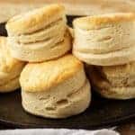 Pile of homemade buttermilk biscuits on cast iron.