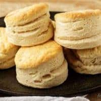 Pile of homemade buttermilk biscuits on cast iron.