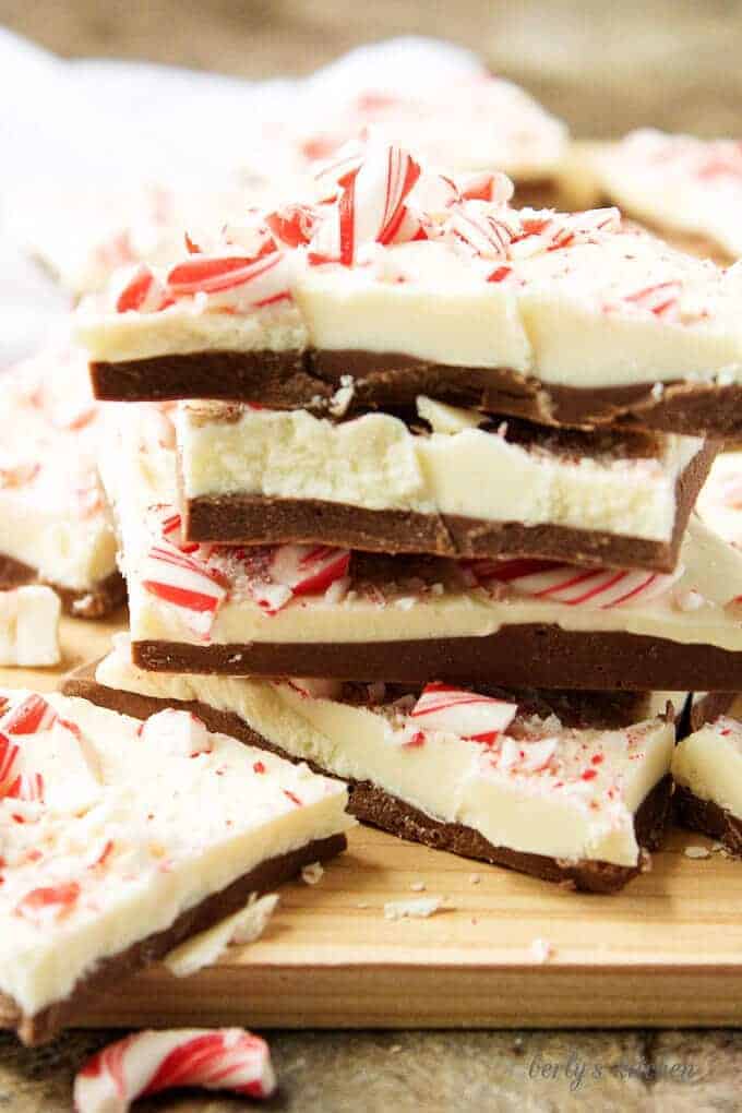 The cooled peppermint bark pieces, stacked up on a wooden cutting for serving.