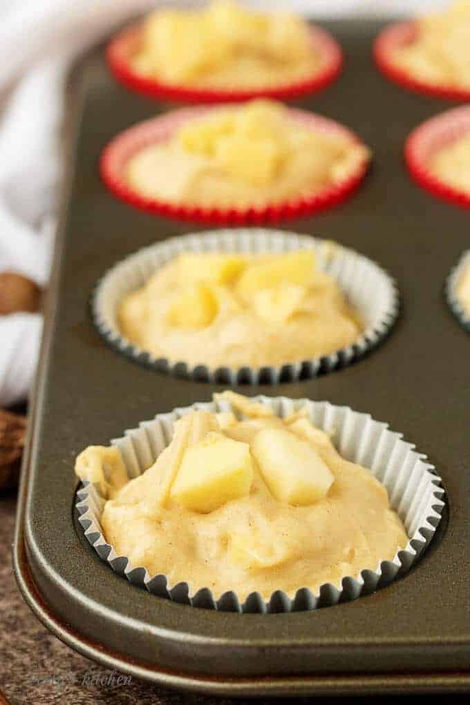 A close-up view of the muffin liners filled with 1/3 cup of batter, ready for the oven.