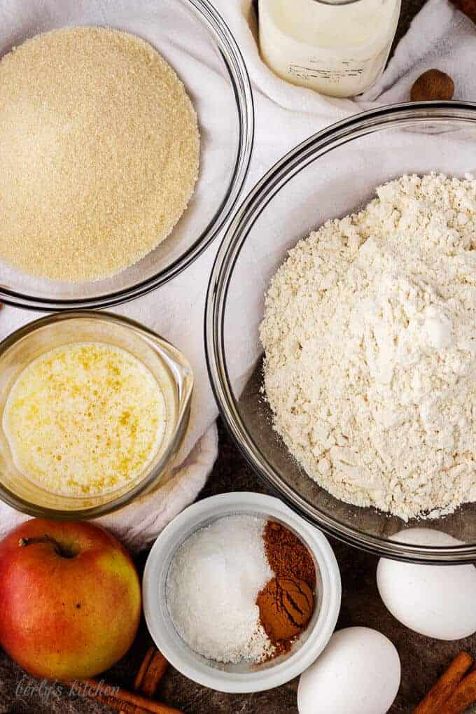 Aerial view of the ingredients like baking powder, cinnamon, apples, and melted butter.