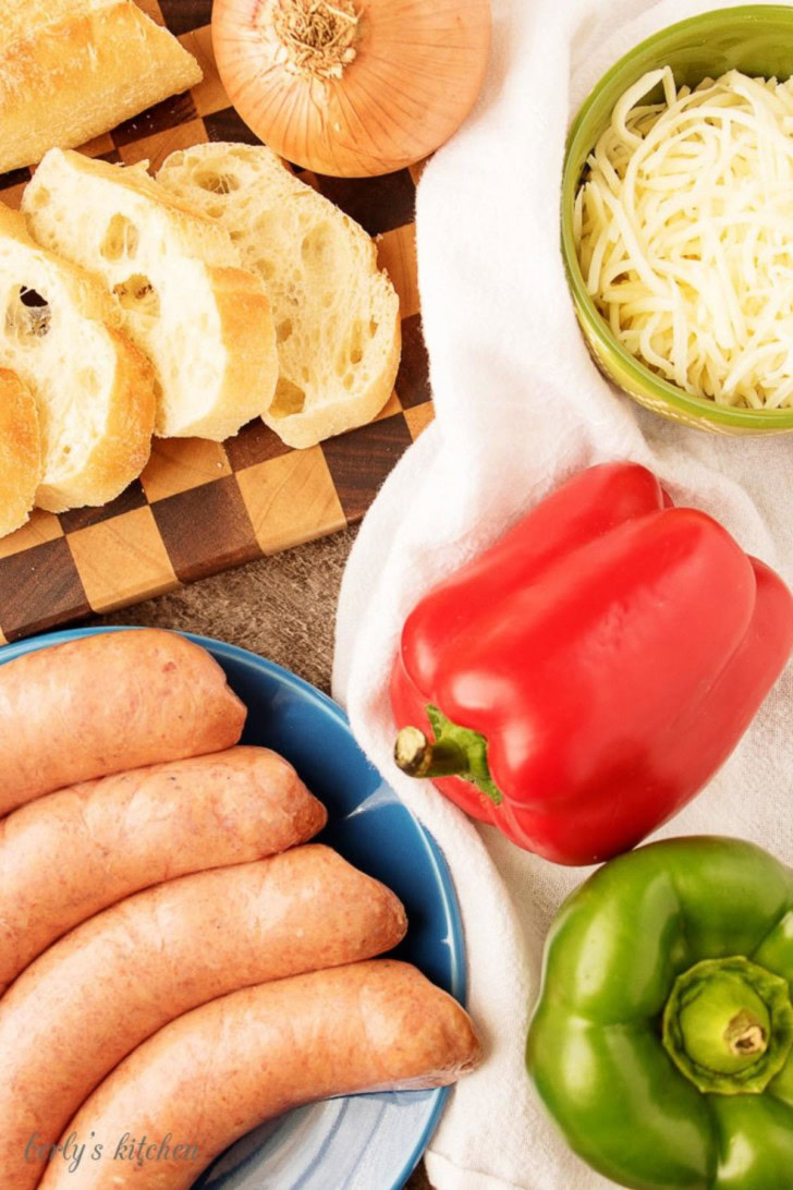 An aerial view of the ingredients like sweet peppers, Italian sausage, and shredded mozzarella.