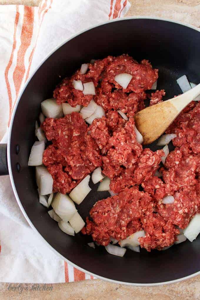 A top-down photo of the meat and onions cooking in the pot.