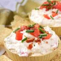 A close-up picture of the finished blt dip in yellow bowls, served with tortilla chips.