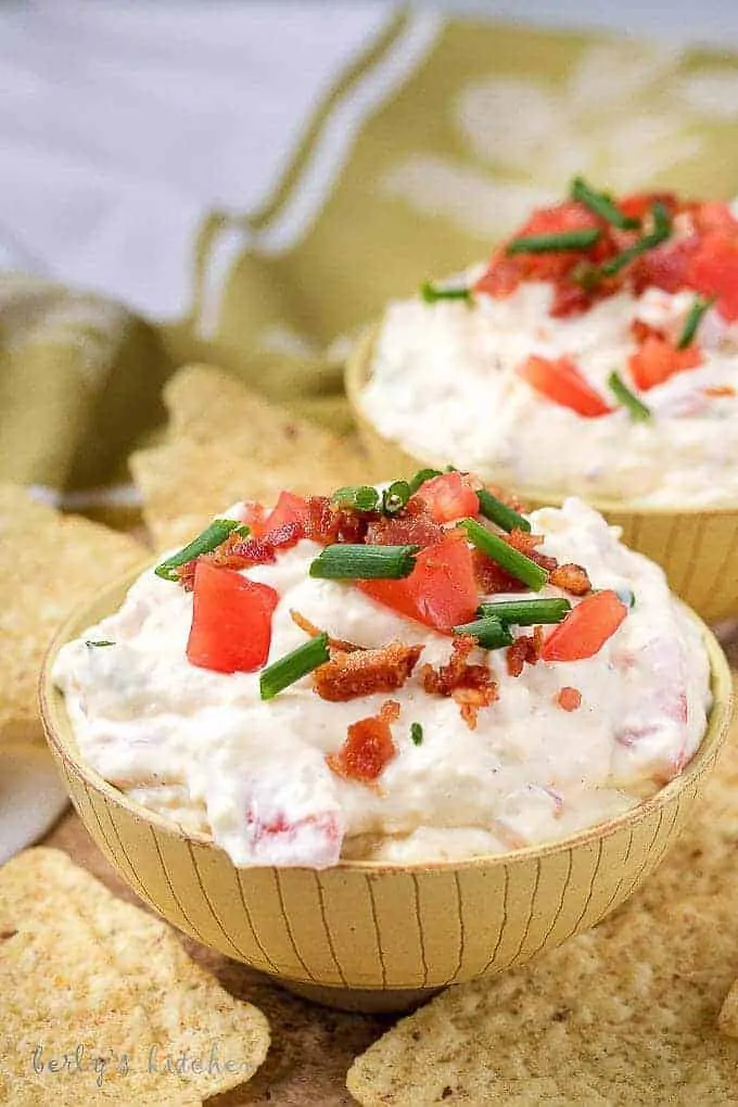 A close-up picture of the finished blt dip in yellow bowls, served with tortilla chips.