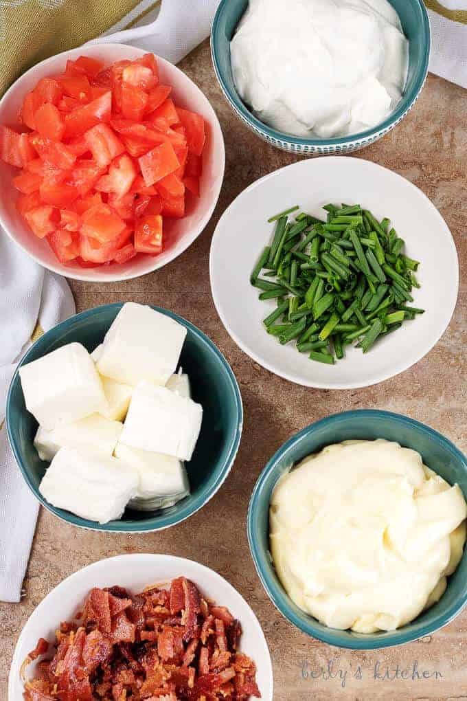 A top-down photo of the ingredients like cream cheese, mayo, tomatoes, and green onions.