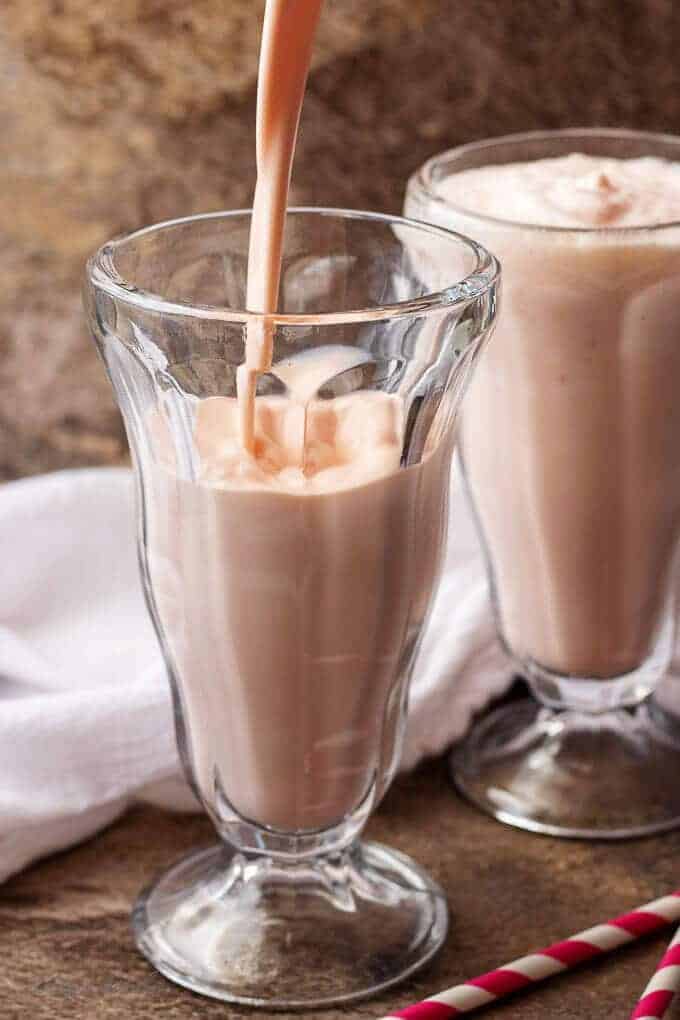 An action photo of the shake being poured into an old fashioned soda glass.