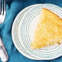 Ariel view of Coconut Custard Pie on a blue and white plate with a blue napkin and two forks.