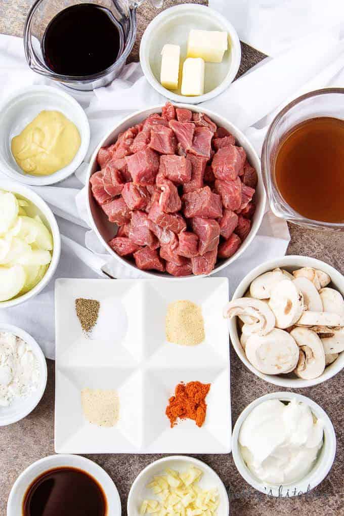 Ariel view of sirloin, spices, mushrooms, onions, garlic, broth, Worcestershire sauce, sour cream, wine, Dijon mustard, and butter used for the easy beef stroganoff recipe.