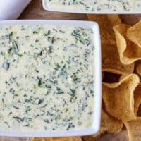 Ariel view of two square bowls of Instant Pot Hot Spinach Dip with tortilla chips