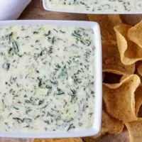 Ariel view of two square bowls of Instant Pot Hot Spinach Dip with tortilla chips