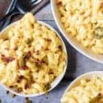 Ariel view of Instant Pot Mac and Cheese topped with bacon and jalapenos in three bowls with two forks.