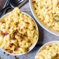 Ariel view of instant pot mac and cheese topped with bacon and jalapenos in three bowls with two forks.