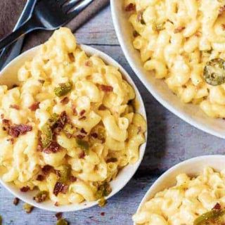 Ariel view of Instant Pot Mac and Cheese topped with bacon and jalapenos in three bowls with two forks.