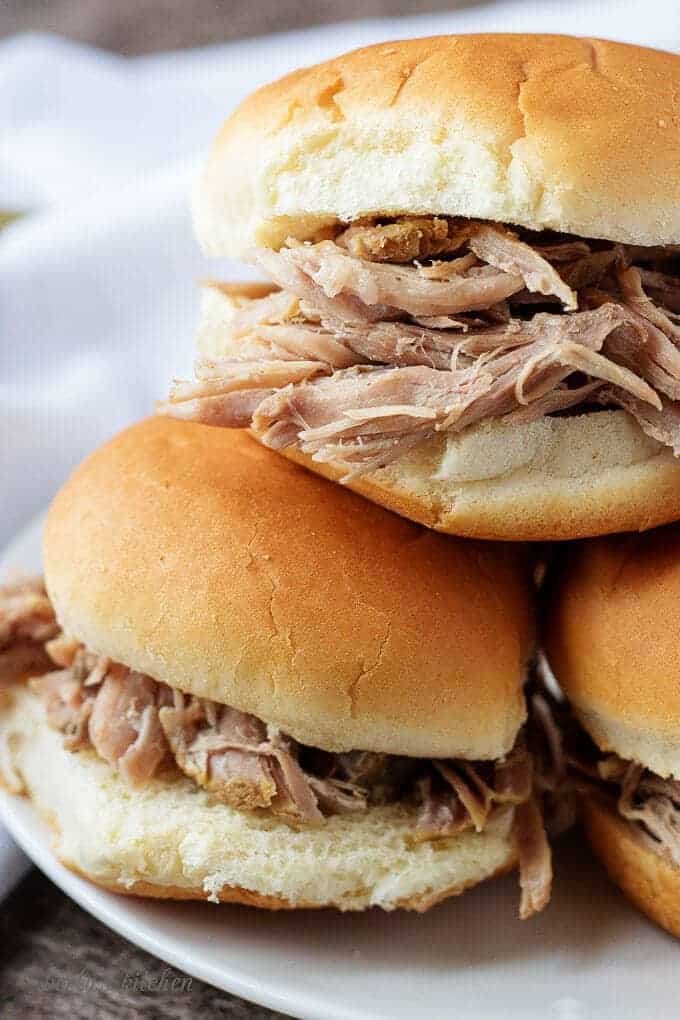 Pork pot roast sandwich stacked on a white plate.