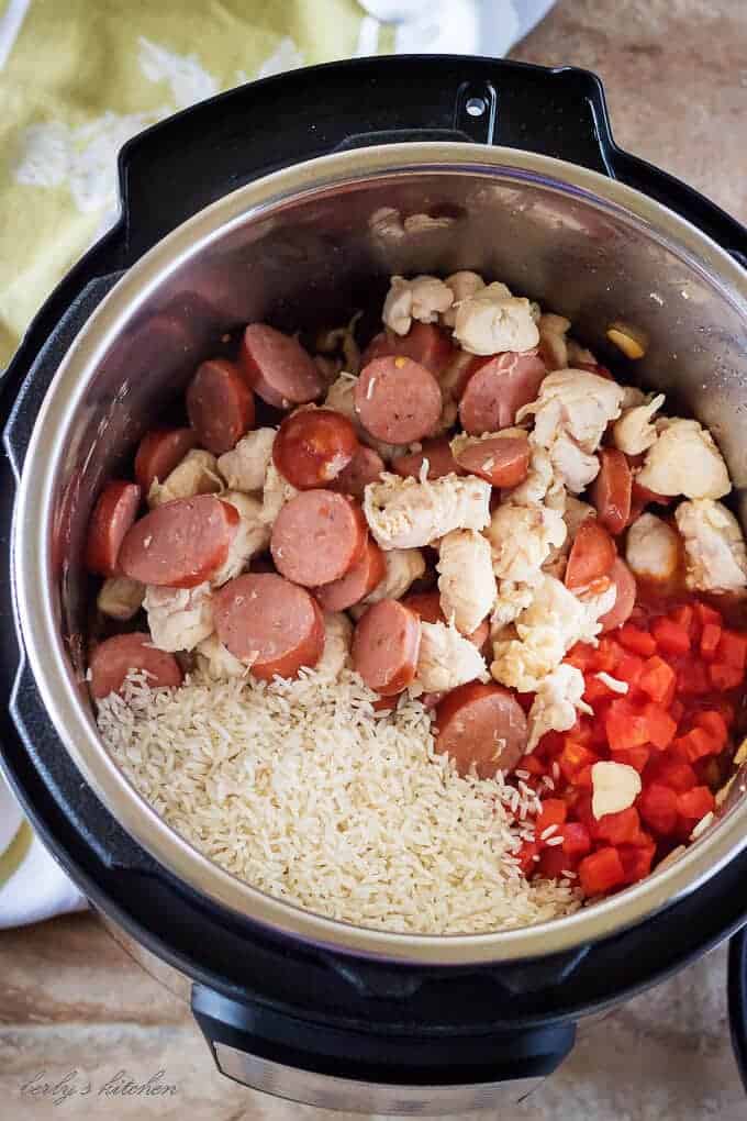 Ariel view of an open Instant Pot with cooked chicken and sausage, tomatoes, and rice for jambalaya.