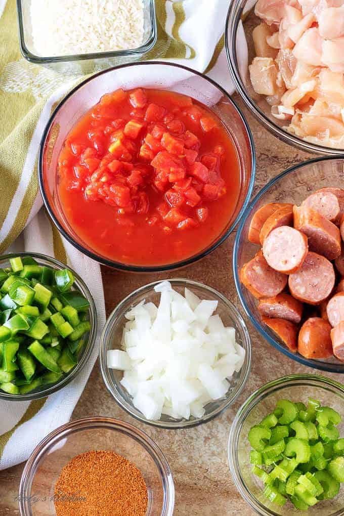 Ariel view of sausage, chicken, tomatoes, rice, onions, peppers, and seasoning used for sausage and chicken jambalaya.