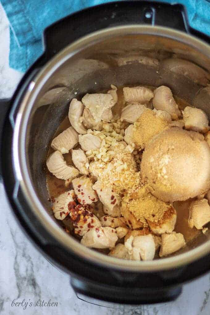 A top-down picture of the mongolian chicken ingredients in the instant pot, ready to seal and cook.