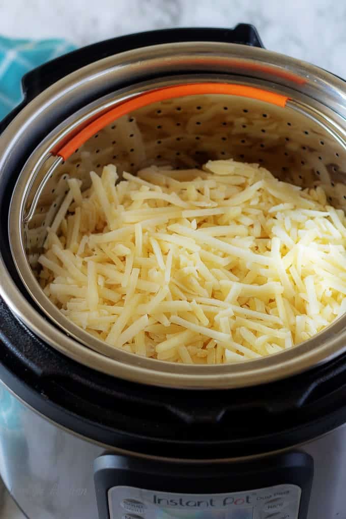 A top-down shot of the hash browns in the steamer basket inside the instant pot.