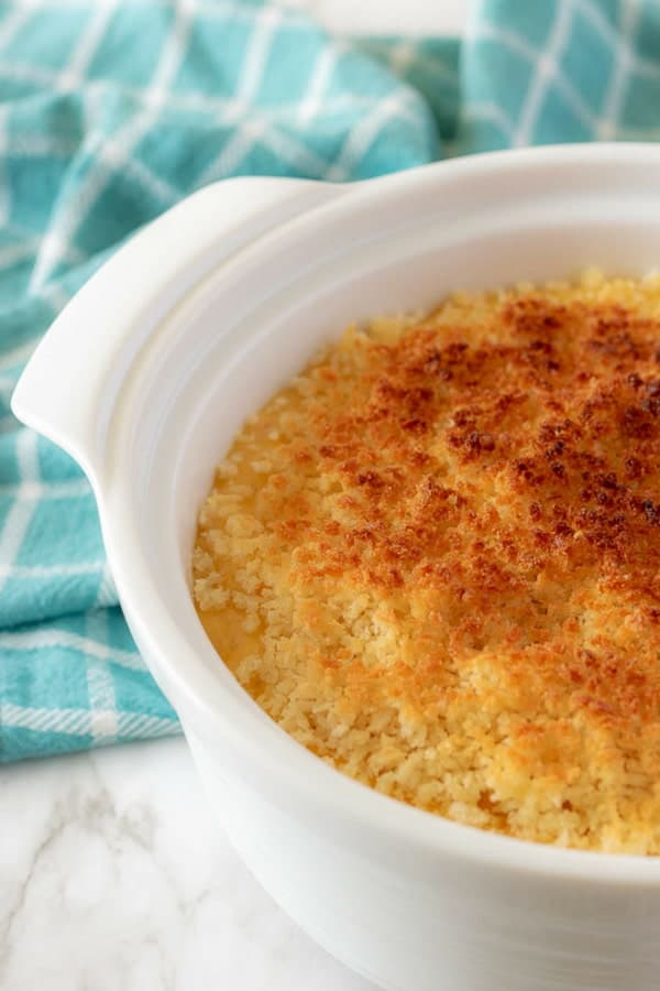 A close-up photo of the funeral potatoes in white casserole dish topped with browned bread crumbs.
